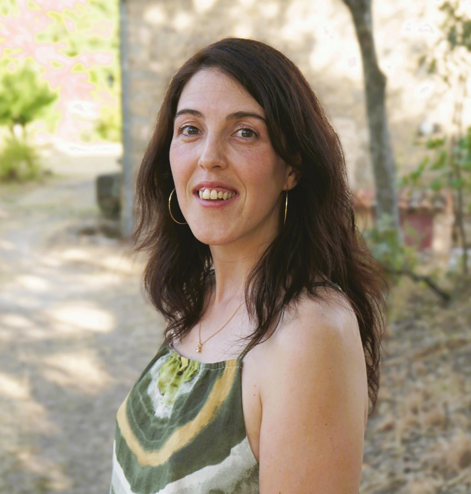Tatiana Rivas Martín sonriendo con expresión cercana, rodeada de vegetación