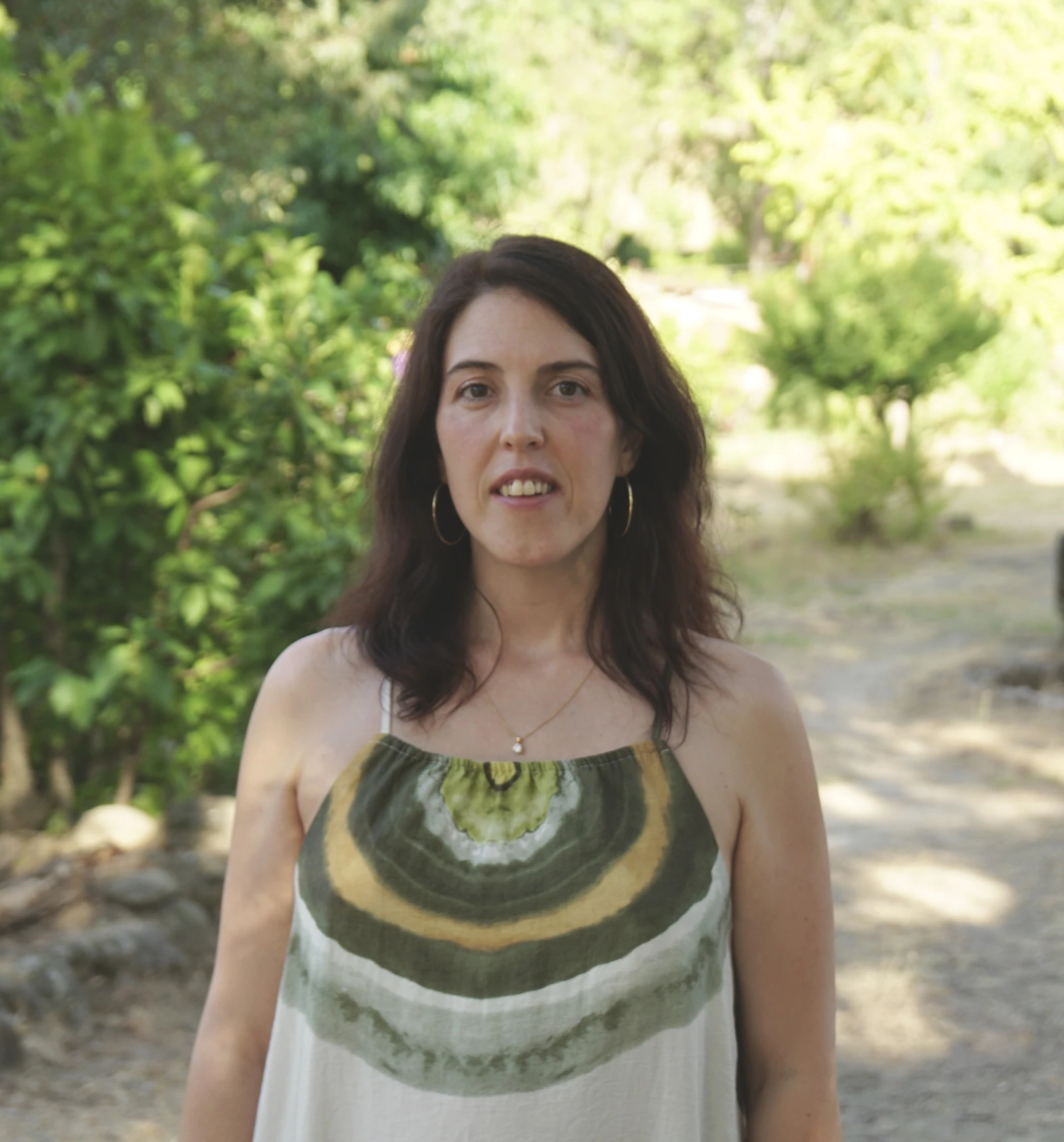 Tatiana Rivas Martín, terapeuta psicocorporal e integrativa, mirando a cámara en un entorno natural